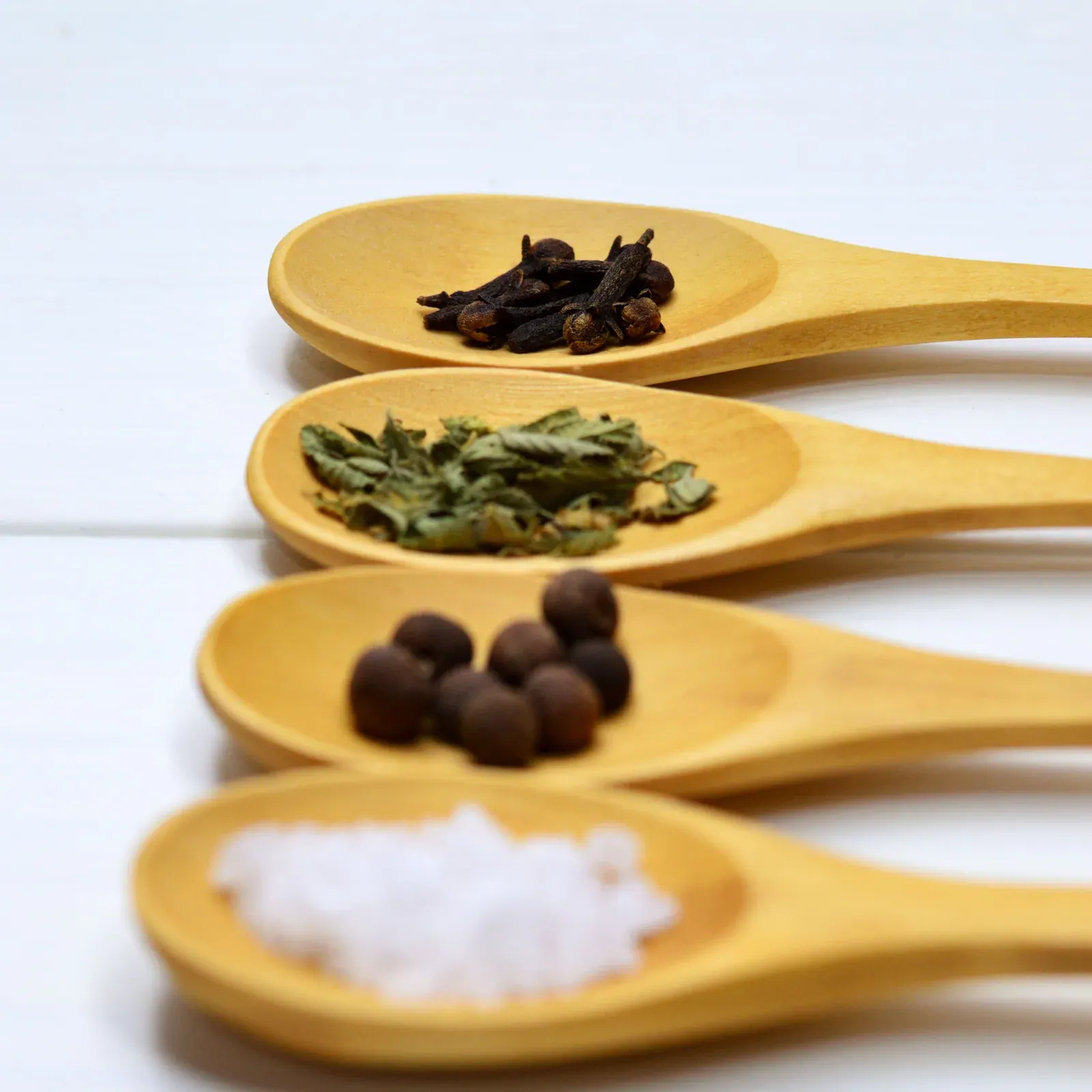 Whole spices on wooden spoons