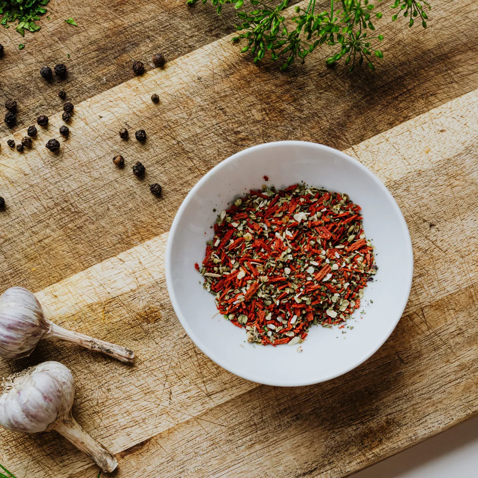 Spices and herbs in bowls on a wooden board
