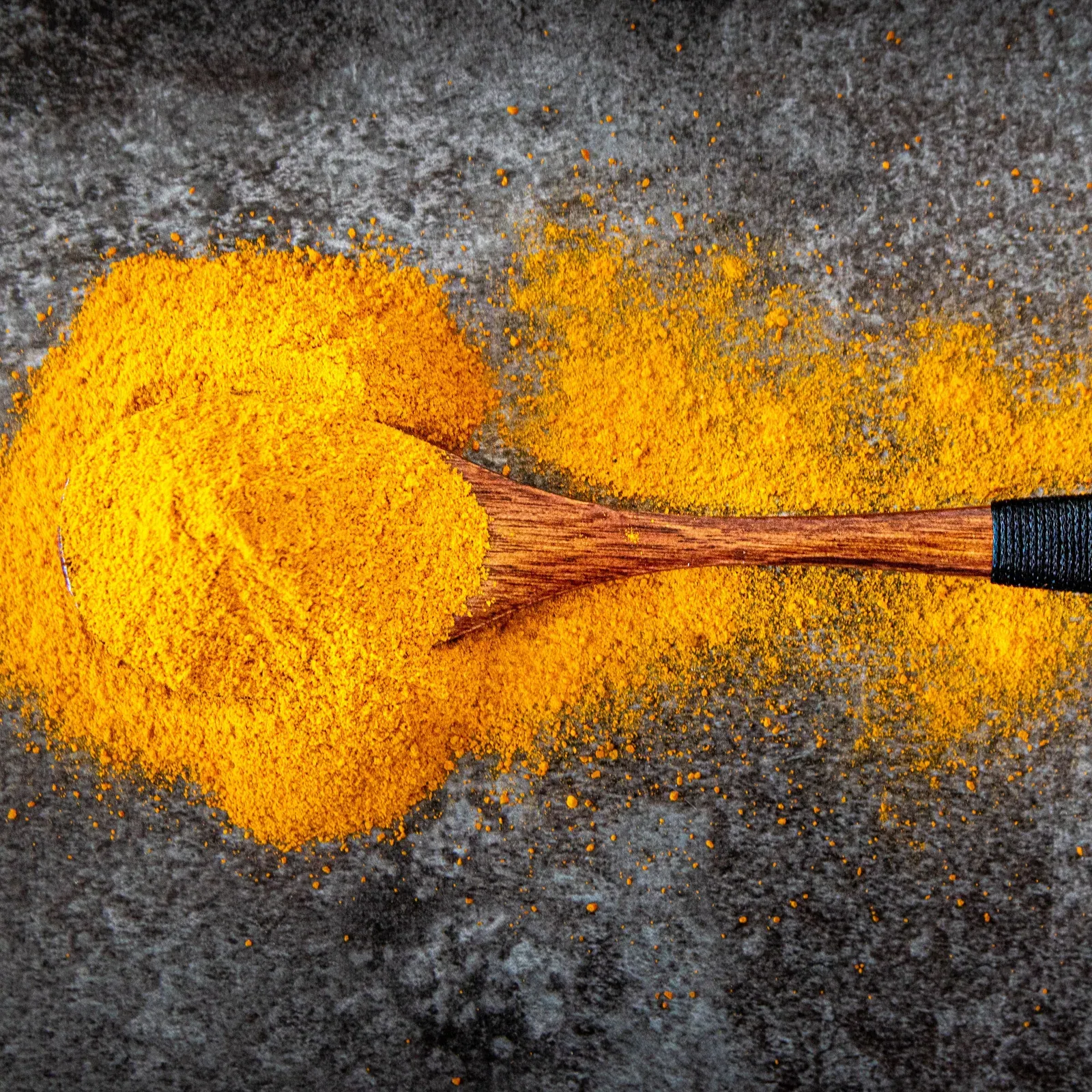 Turmeric powder with a wooden spoon