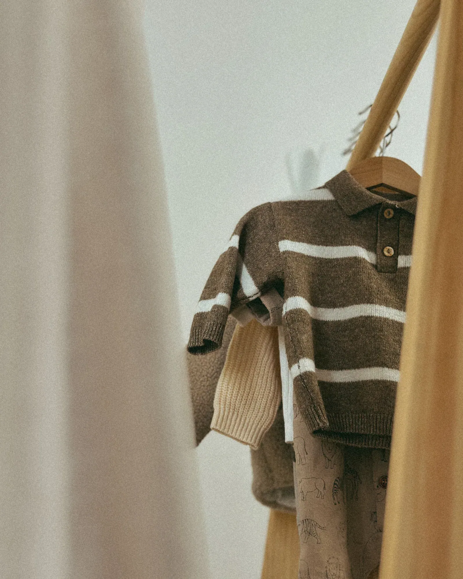 Brown and cream striped knit top on a child's wooden clothes rack