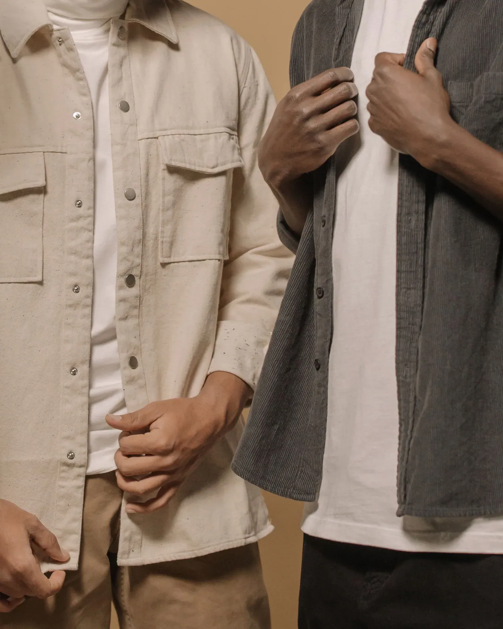 Two men in stone and charcoal overshirts, shown from the shoulders down