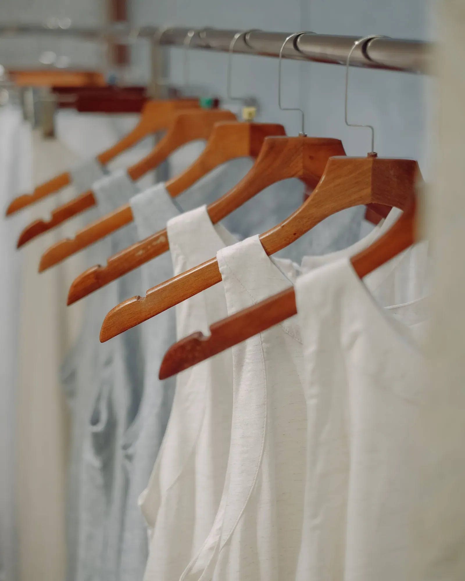 White blouses on wooden hangers on a rail