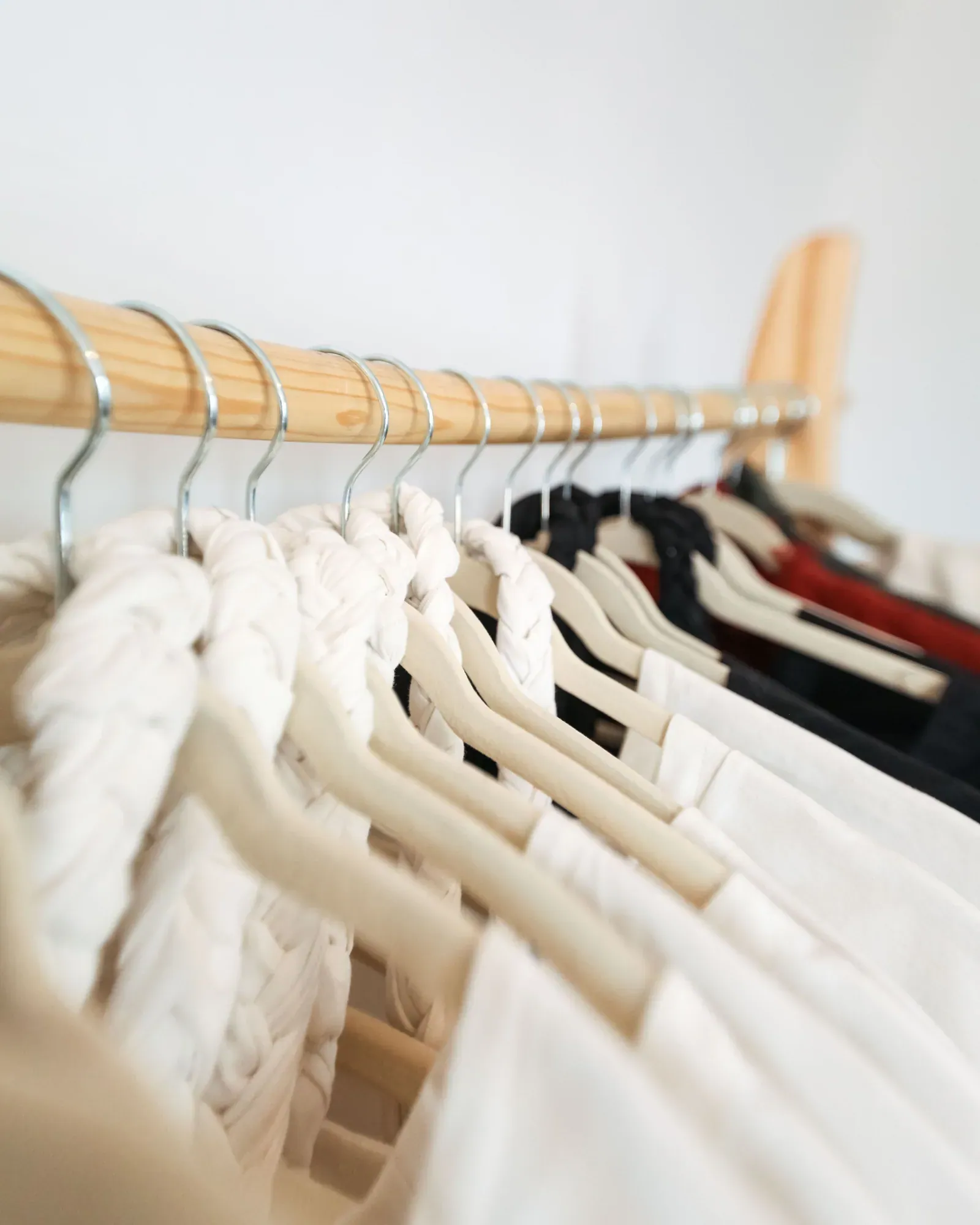 Cream and white shirts on a wooden rail